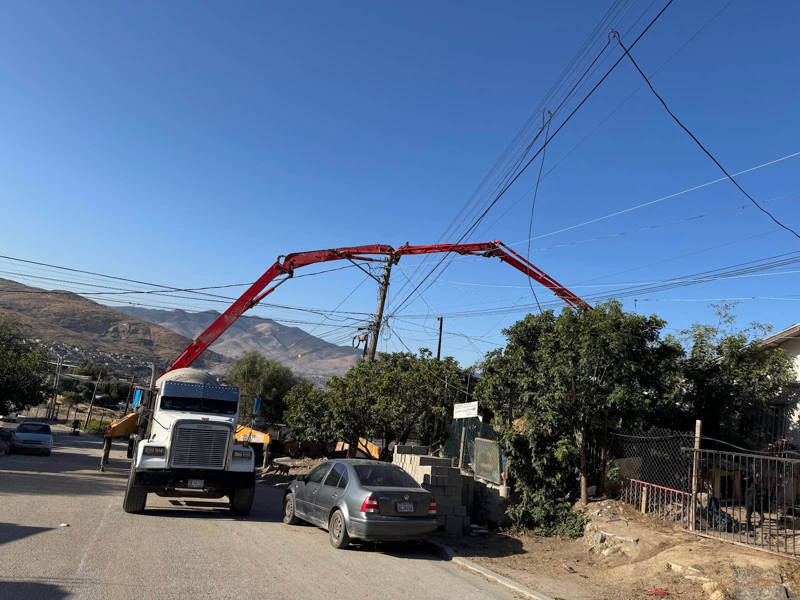 Bomba pluma de Diez Concretos colocando concreto en calle de zona residencial
